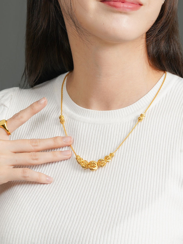 A women wearing 916 Gold 5 Ball Necklace
